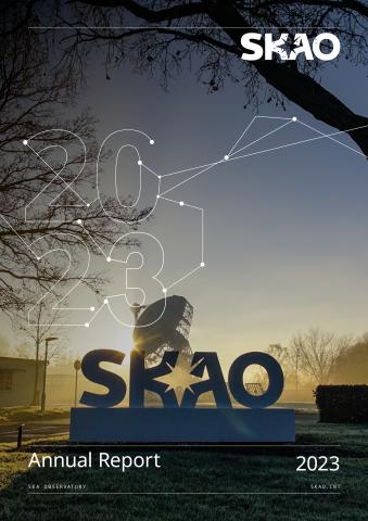 The front cover of the SKAO 2023 annual report. The picture shows the SKAO logo in front of a misty morning with a telescope dish in the background. 