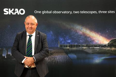 Dr Filippo Zerbi standing in front of an SKAO banner. The banner reads: One global observatory, two telescopes, three sites. 